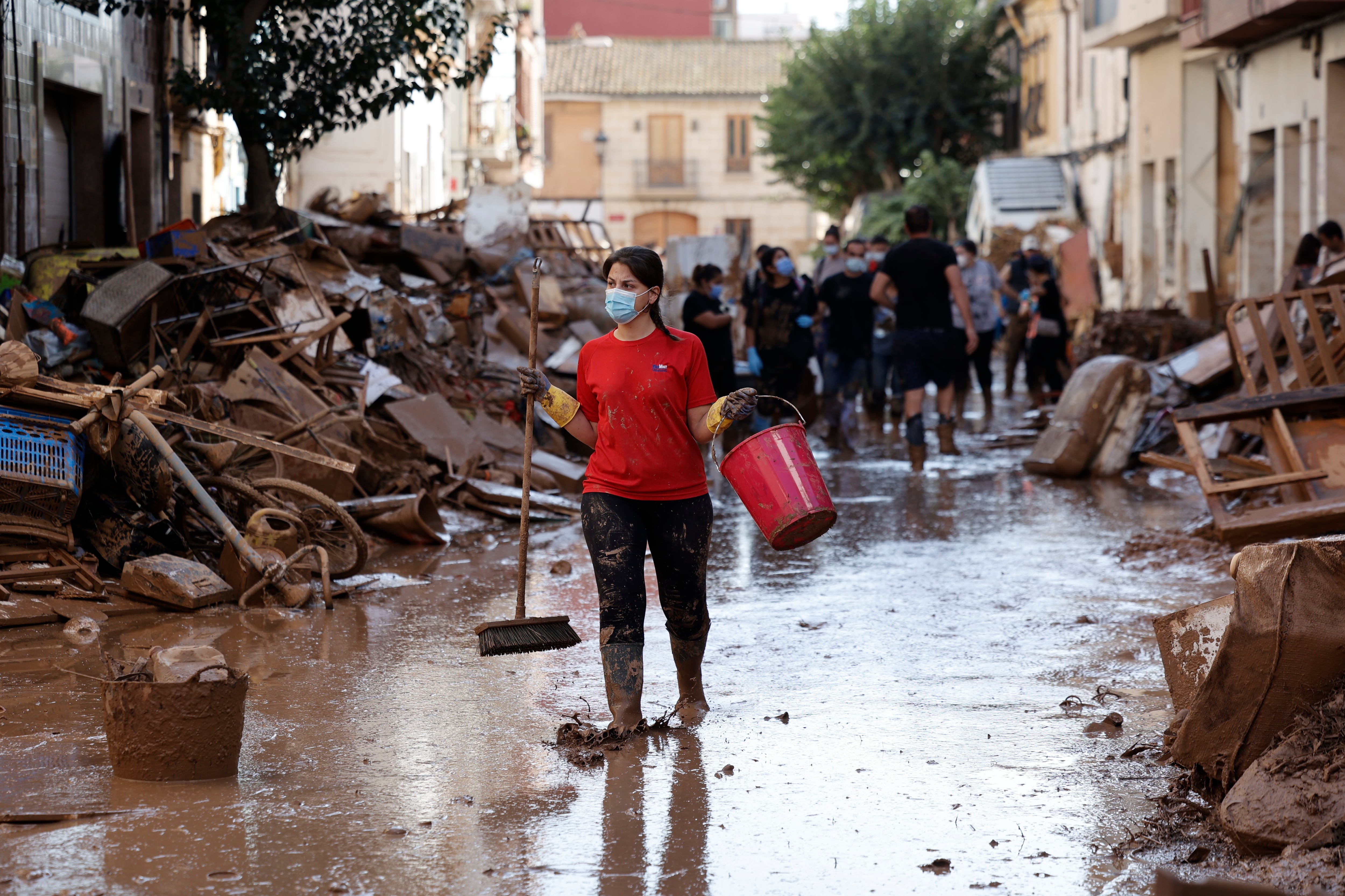 PAIPORTA (VALENCIA), 02/11/2024.- Varias personas retiran el lodo acumulado en una calle de la localidad valenciana de Paiporta, este sábado. Por tercer día consecutivo una marea de voluntarios ha llegado este sábado a barrios del sur de la ciudad de València y a los pueblos de la comarca vecina de lHorta Sud asolados por la dana para luchar contra un fango, donde grupos especializados de los equipos de intervención buscan cadáveres en garajes o fosos aún anegados.EFE/ Biel Alino
