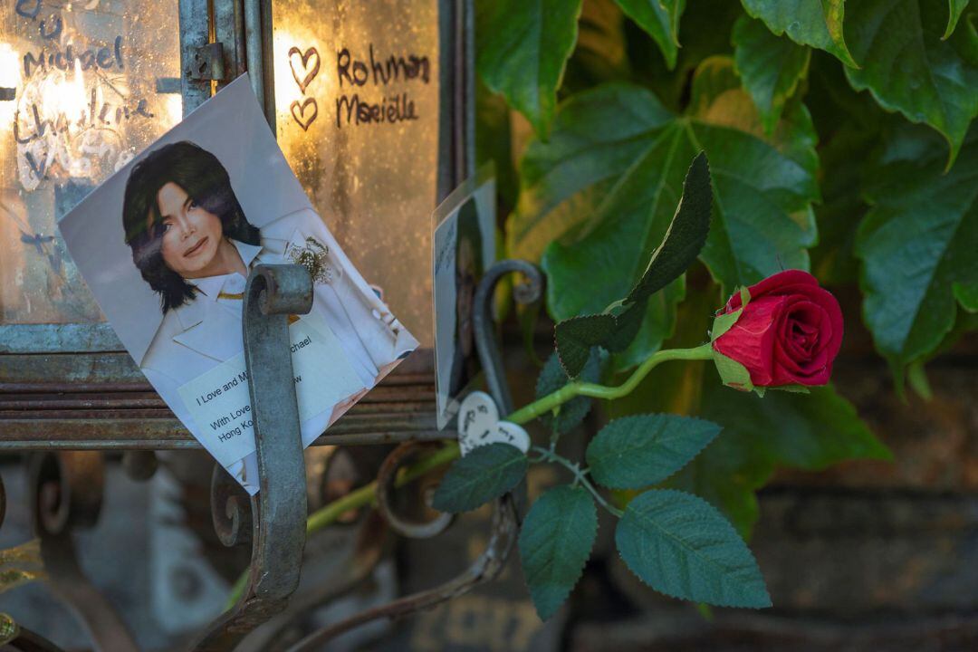 Una fotografía del cantante al lado de una rosa en la puerta del rancho Neverland.