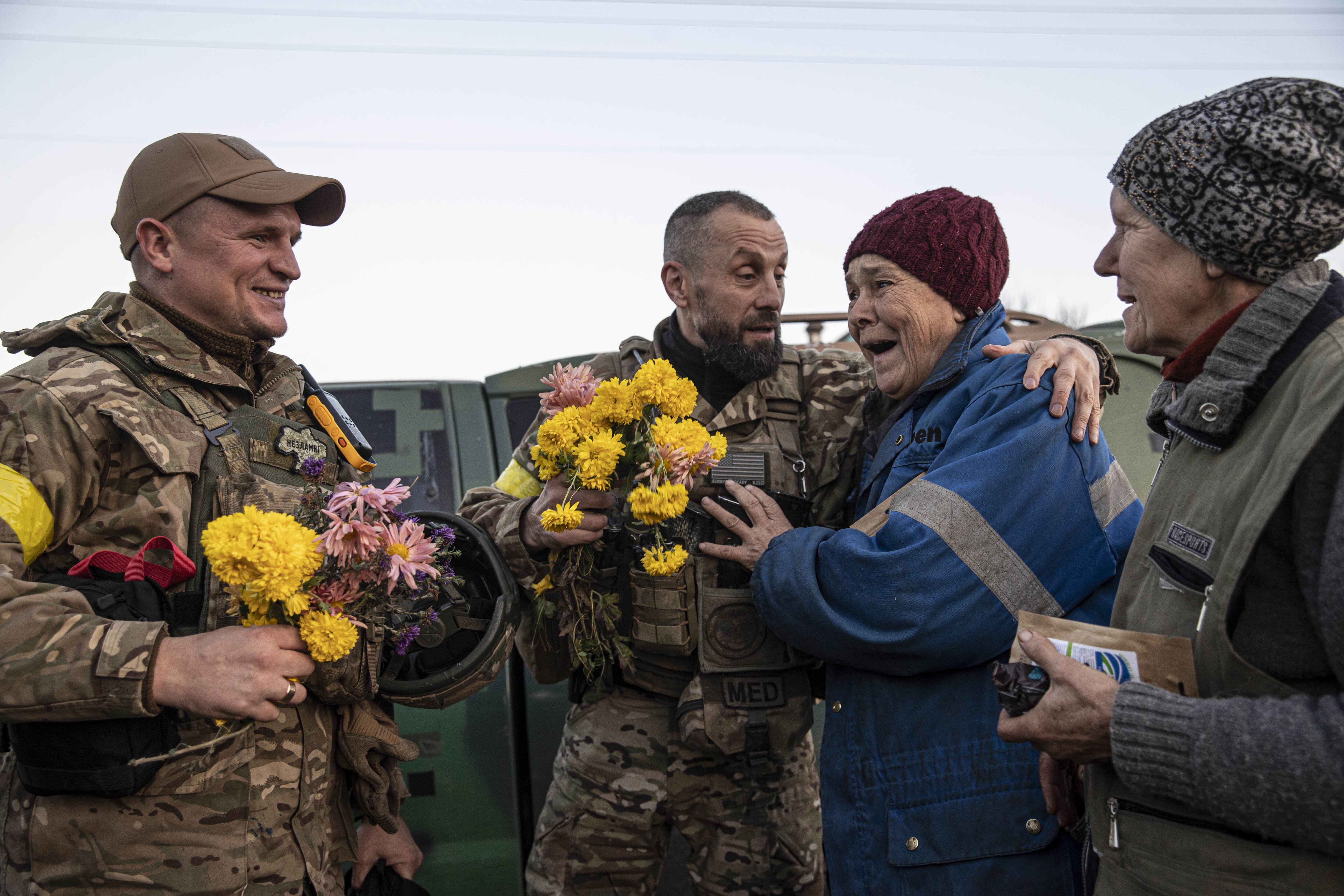 Dos mujeres dan la bienvenida con flores a los soldados ucranianos tras la liberación de la ciudad de Jersón de la ocupación rusa, el sábado en una aldea cercana a la ciudad