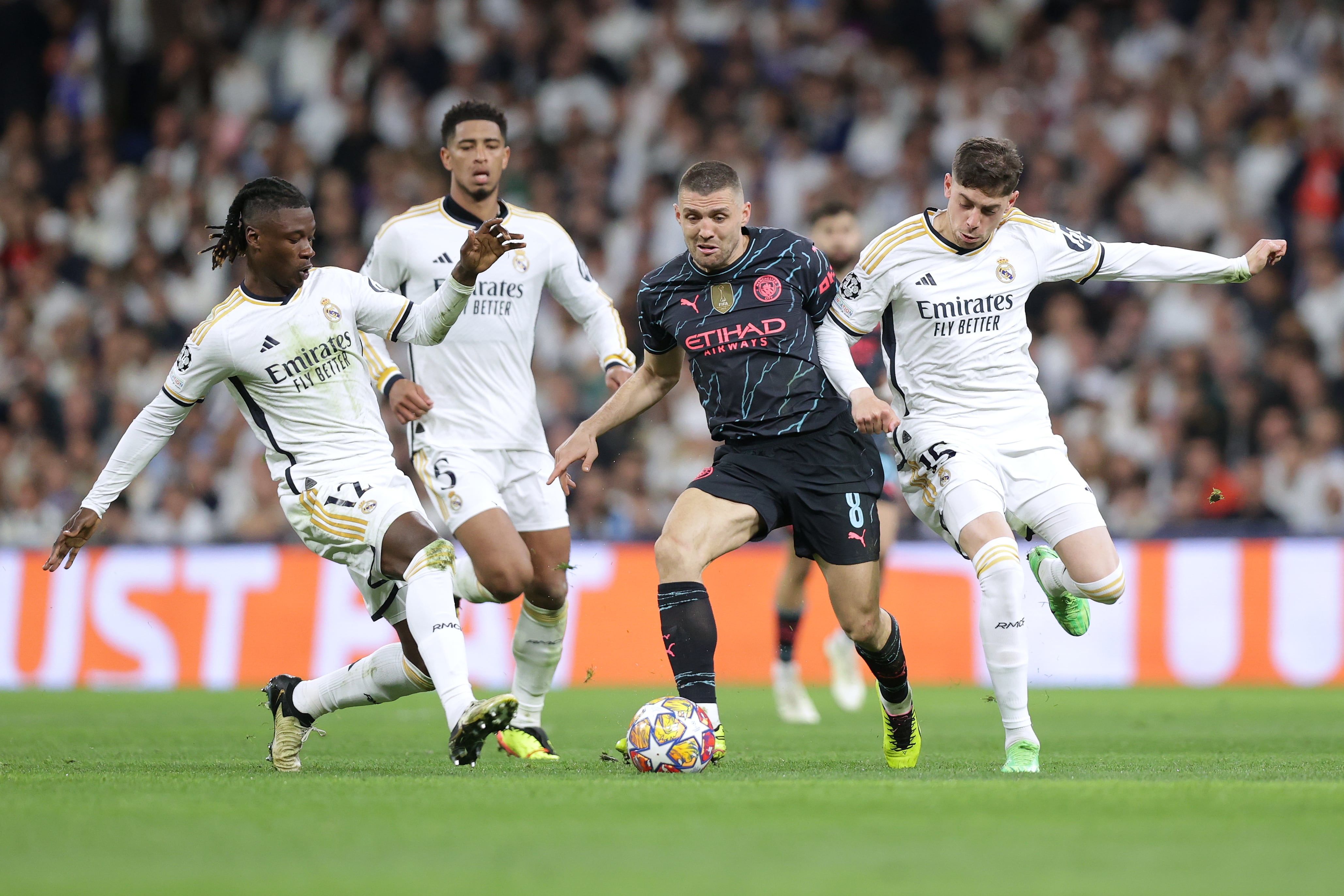 Eduardo Camavinga y Fede Valverde intenta robarle el balón a Mateo Kovacic