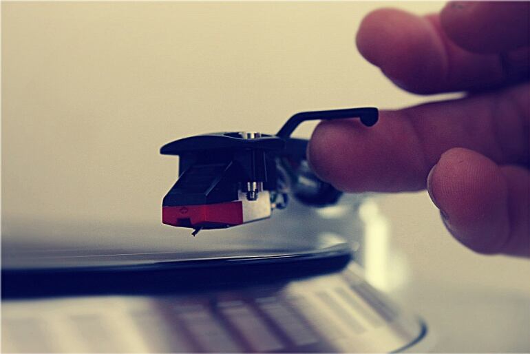 Una persona a punto de poner pinchar un disco en un tocadiscos