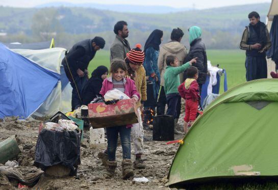 Una niña refugiada transporta comida en el campamento provisional de Idomeni, en la frontera entre Grecia y Macedonia