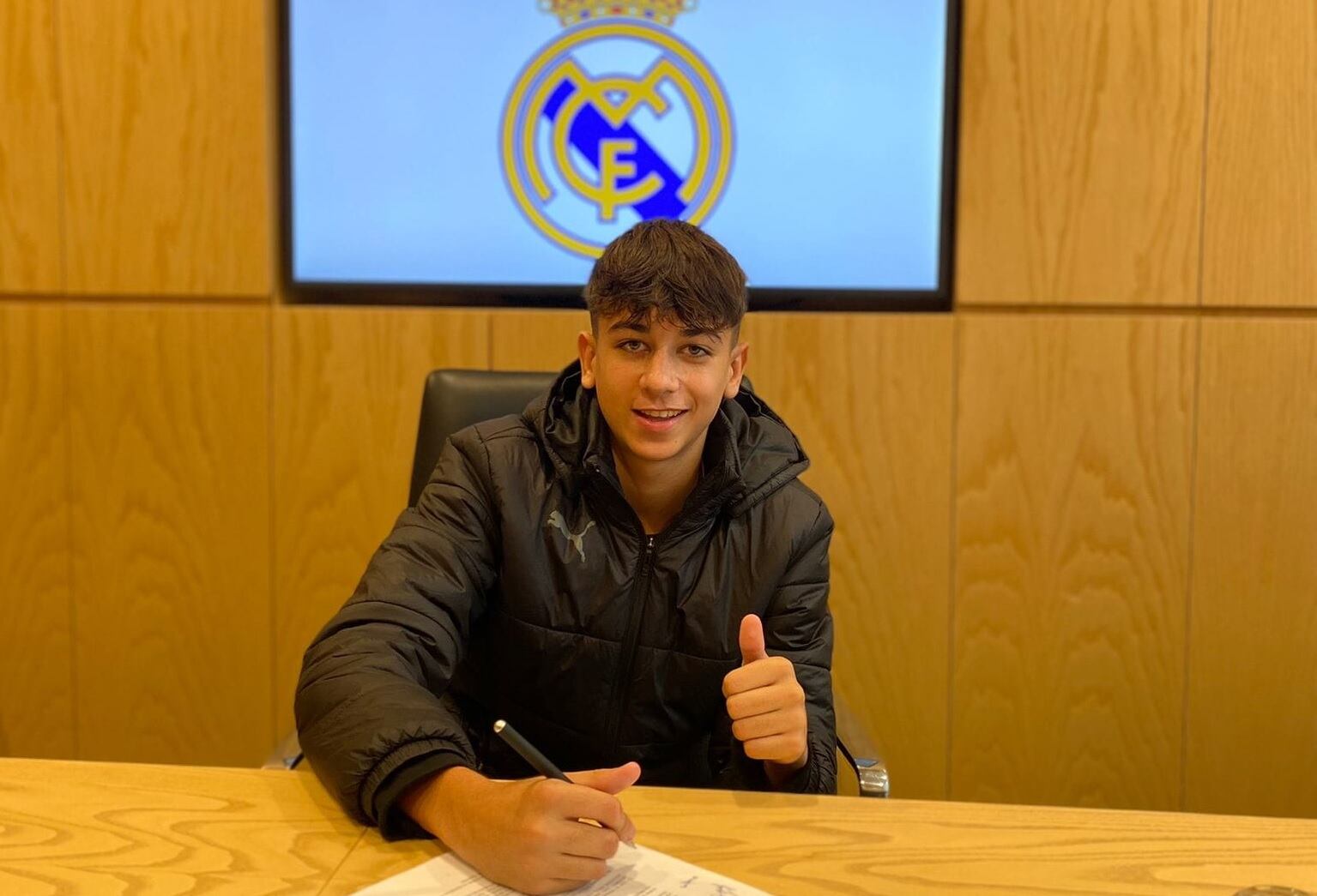 Marcos Romero firmando su nuevo contrato con el Real Madrid.