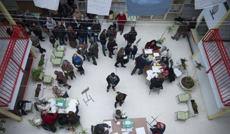 Numerosos ciudadanos hacen cola antes de votar en las elecciones autonómicas para la Junta de Andalucía, hoy en un colegio de Málaga. Los 9.873 mesas electorales andaluzas han abierto hoy con normalidad para que puedan ejercer su derecho al voto los 6.496.685 electores convocados en los décimos comicios andaluces