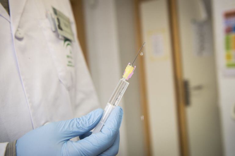 Un enfermero se dispone a vcunar a un niño en un centro de salud español. 