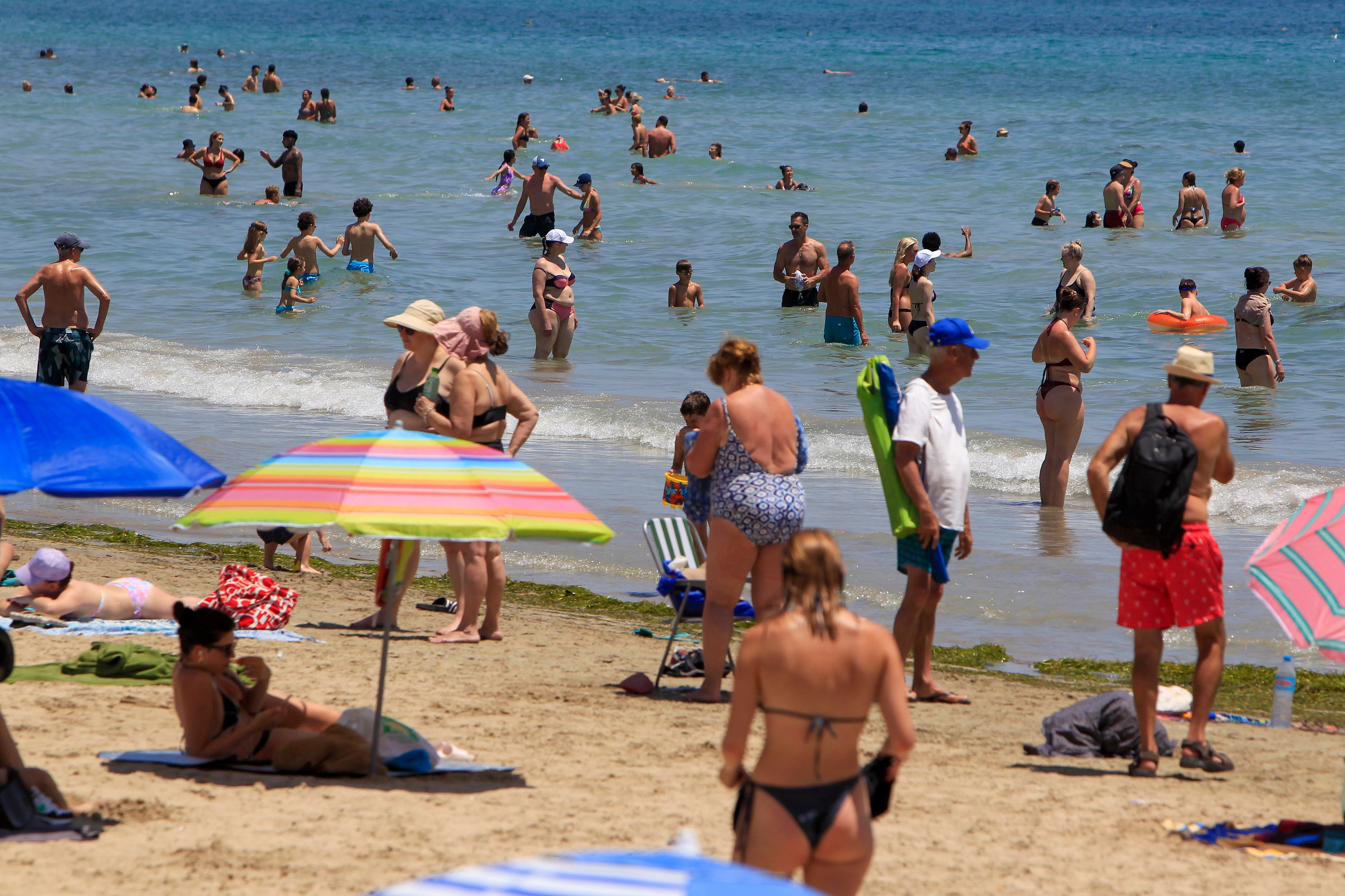 Un gran número de personas se refresca en la playa de Alicante cuando el calor ha disparado la temperatura del mar. EFE/Morell.