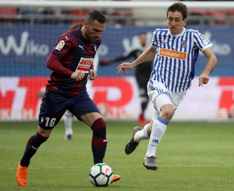 El defensa del Eibar, Anaitz Arbilla, conduce el balón ante la marca del delantero de la Real Sociedad, Mikel Oyarzabal.