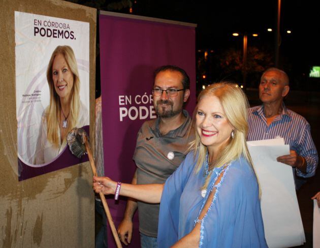 La candidata de Podemos, Cristina Pedrajas, colocando cartelería electoral.