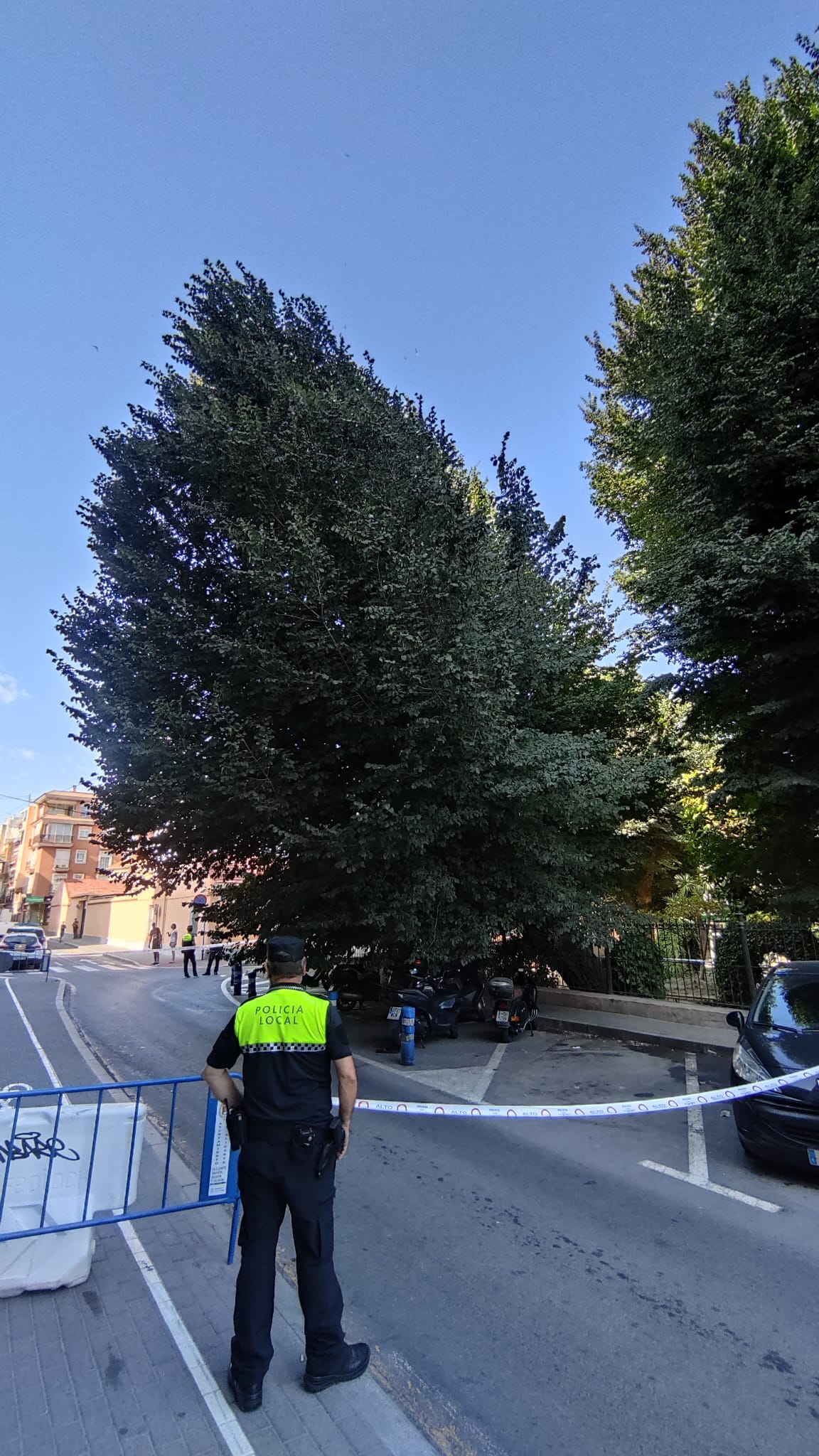 Un agente de la Policía Local controlando el perímetro para impedir el paso de personas mientras se retiran las motocicletas aparcadas en la zona afectada