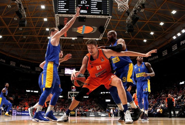 El pívot del Valencia Basket Tibor Pleiss (c) juega un balón ante Alex Tyus (d), del Maccabi Tel Aviv, durante el partido de la fase regular de la Euroliga de baloncesto que se ha disputado esta noche en el pabellón de la Fuente de San Luis, en Valencia. 