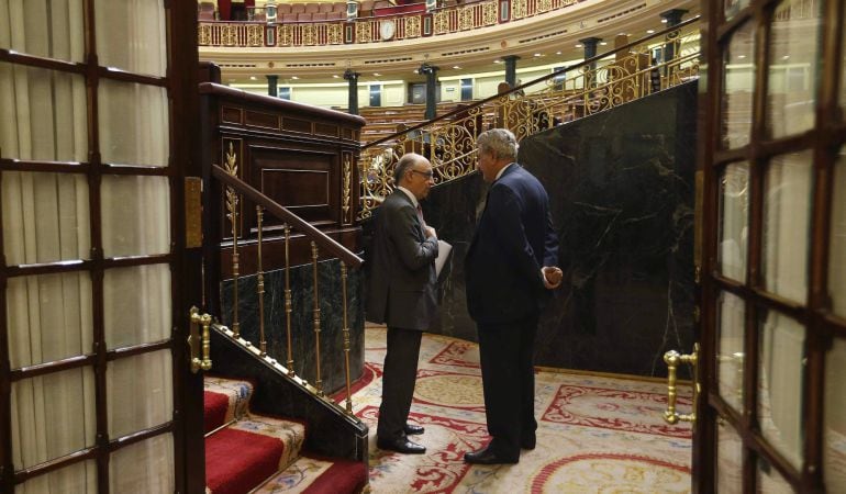 El ministro de Hacienda, Cristóbal Montoro, conversa con el presidente de la Cámara Baja, Jesús Posada, durante un pleno en el Congreso de los Diputados.