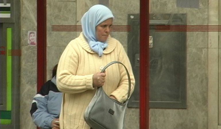 Una mujer extranjera en una parada de autobus de Alcobendas