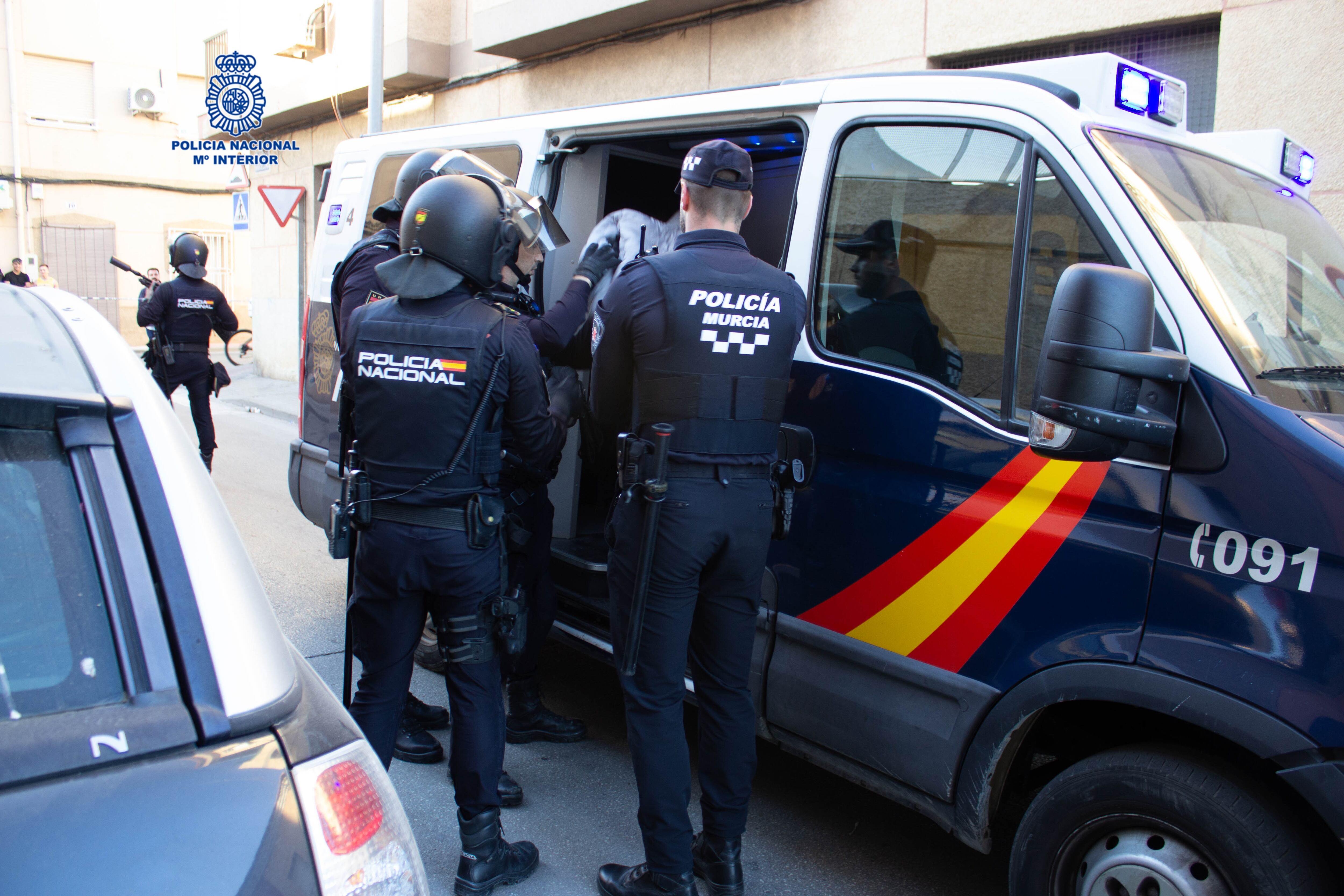 Los agentes introducen en un furgón policial a uno de los detenidos