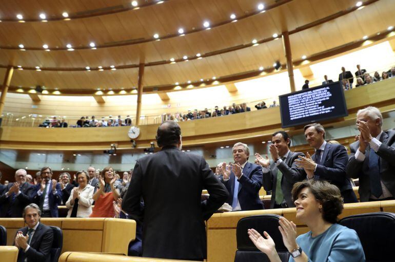 El presidente del Gobierno, Mariano Rajoy (abajo - c), recibe los aplausos de los miembros del grupo parlamentario popular.