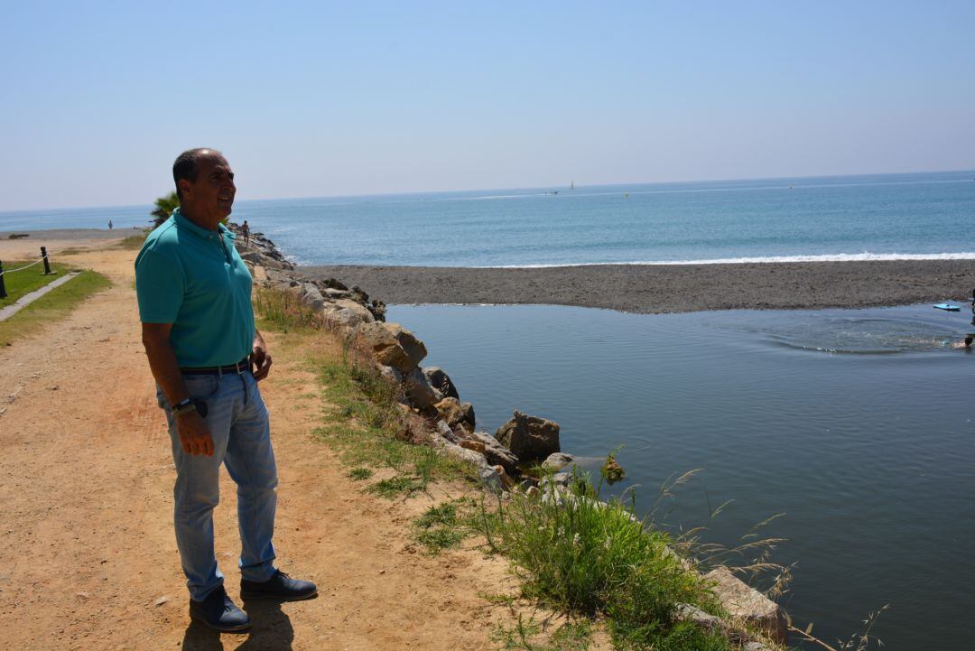 El concejal sanroqueño, Juan Serván, junto a la desembocadura del río totalmente taponada.