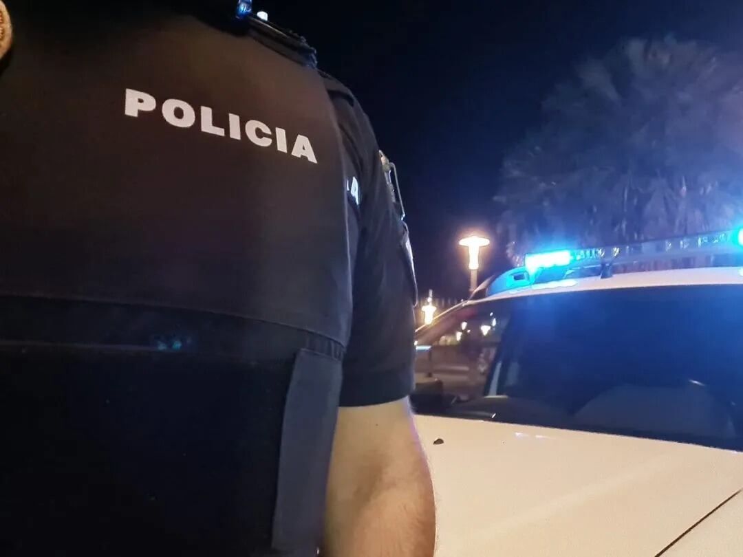Agente de la Policía Local de Jaén delante de un vehículo.