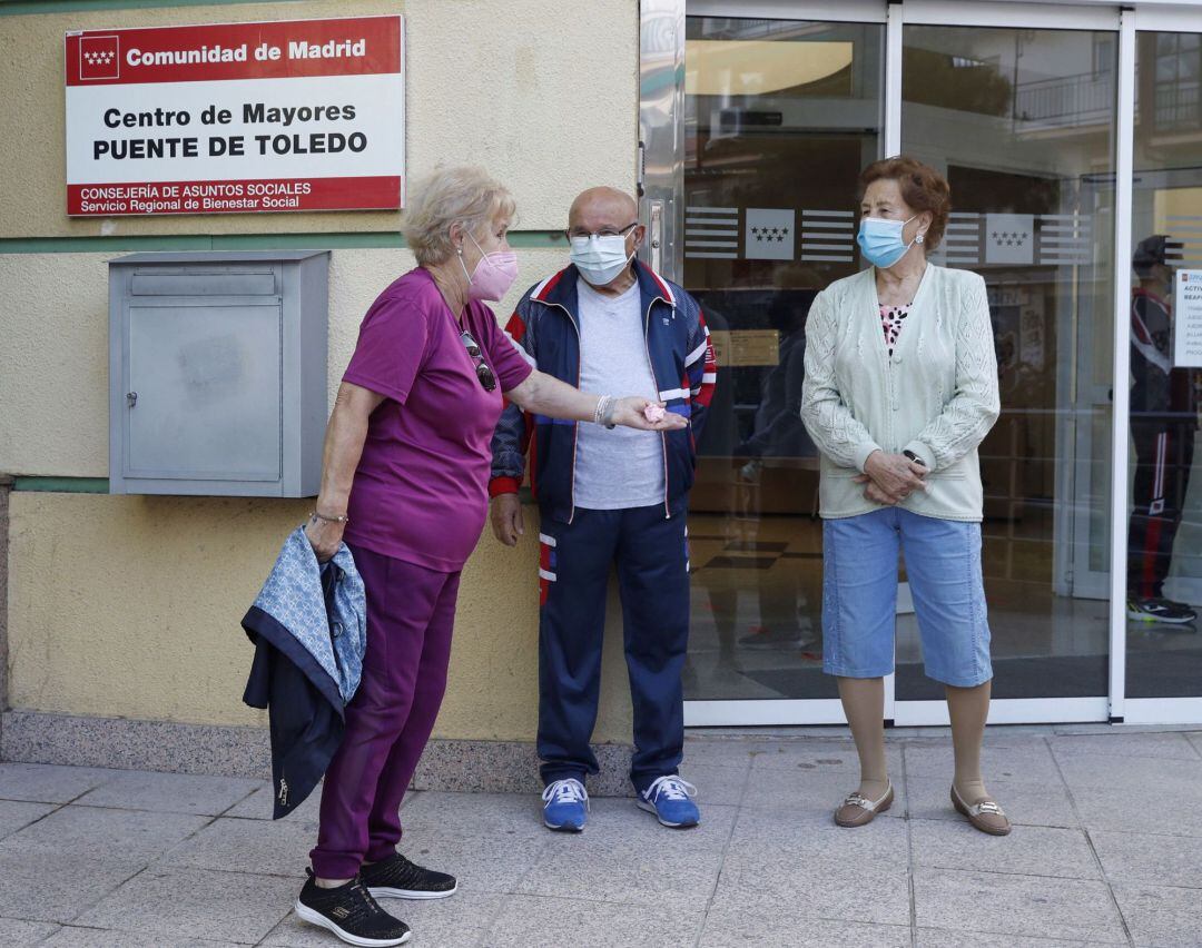 Varios mayores conversan a las puertas del centro de mayores Puerta de Toledo de Madrid, este lunes, día de reapertura de estos centros en la Comunidad. 