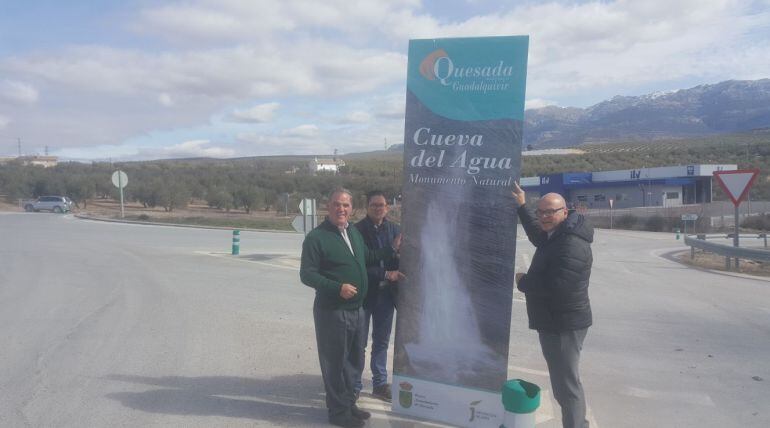 El alcalde de Quesda, Manuel Valluejo, el concejal de cultura, Juan Antonio López y el diputado de promoción y turismo, Manuel Fernández posan junto al nuevo tótem instalado en la rotonda junto a la ITV