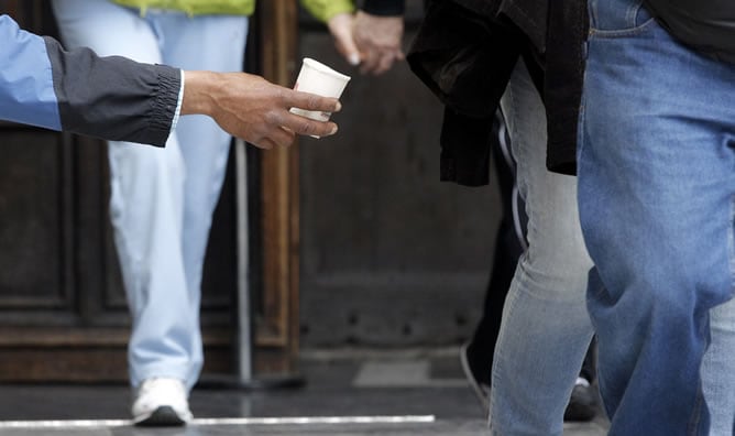 Un hombre pide dinero en la calle