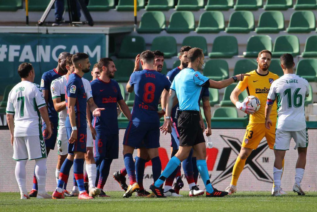 El colegiado señala el punto de penalti tras las manos de Marcos Llorente.