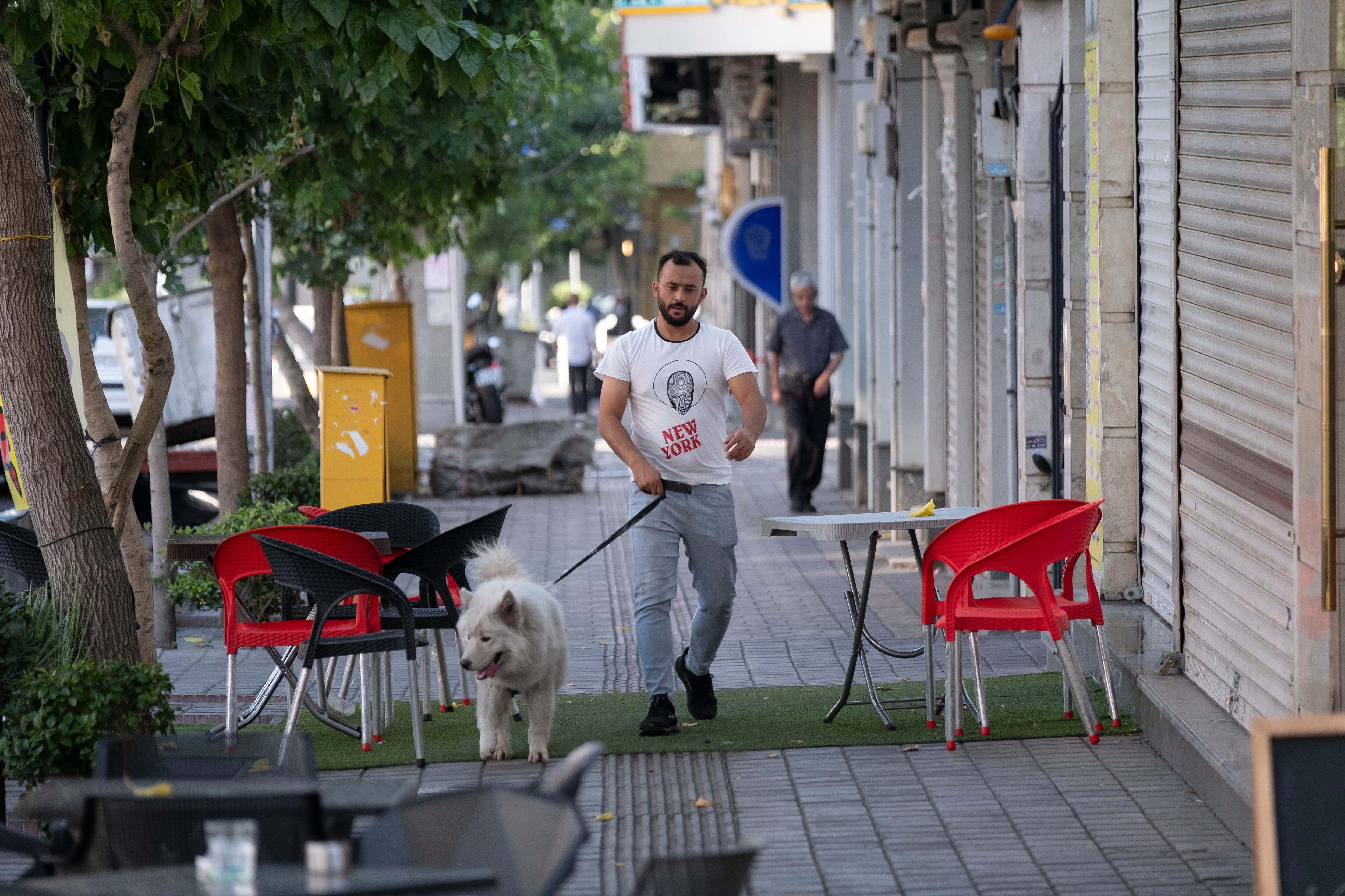 Un joven iraní y su perro caminan en el centro de Teherán, Irán, el 17 de junio de 2024. Morteza Nikoubazl/NurPhoto.