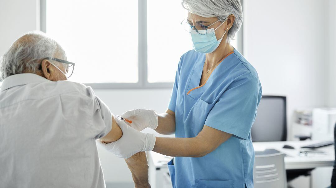 Una enfermera inocula la vacuna a un hombre