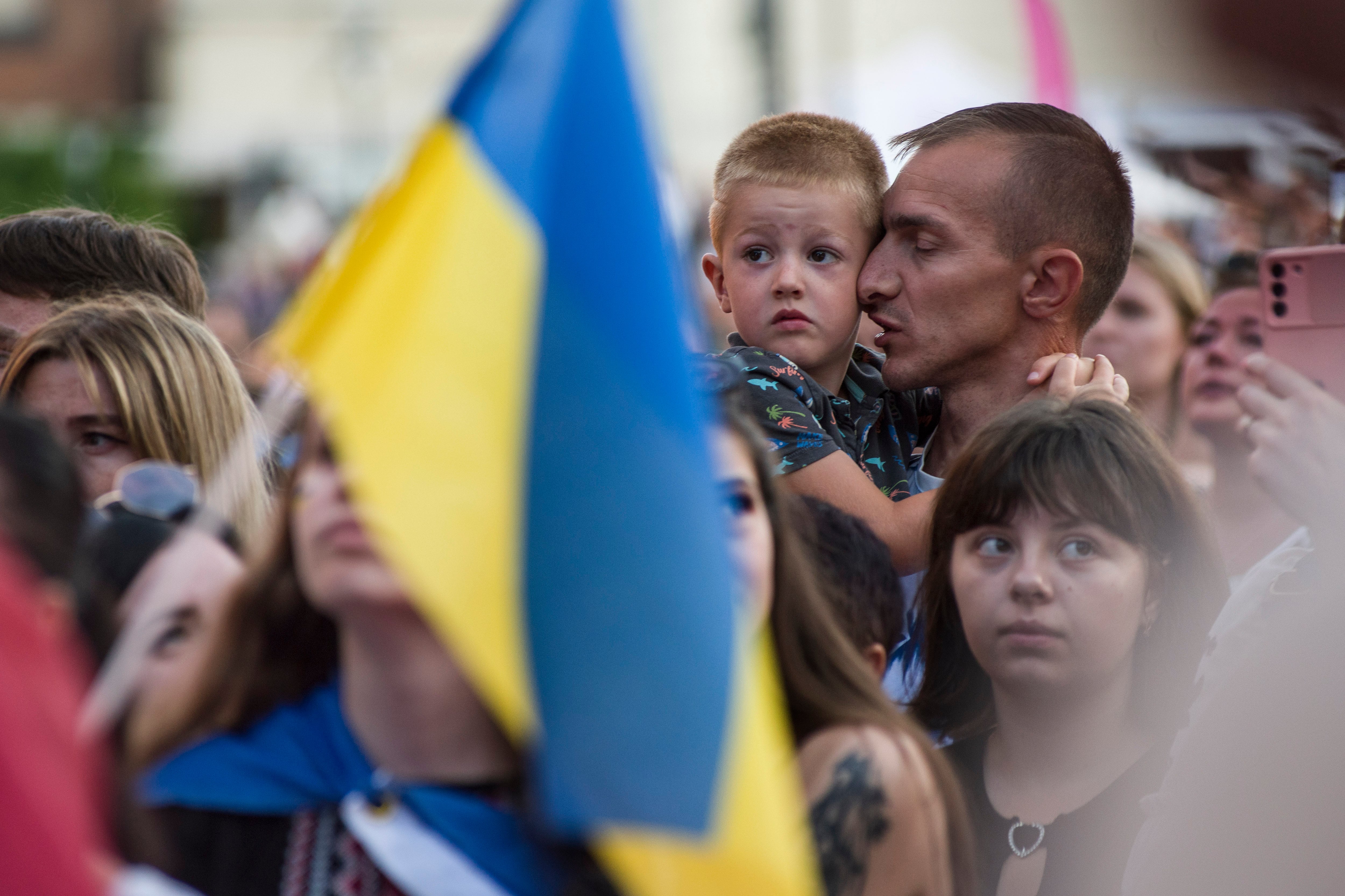 Un hombre ucraniano besa a su hijo durante una manifestación en Varsovia