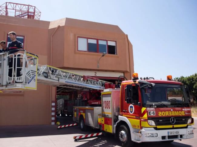 Luis Palma (i) y Daniel Arreza (d), los bomberos que ayer rescataron a una niña de 5 años que se encontraba colgada del balcón de un octavo piso de Málaga, manipulan la autoescala de treinta metros con la que accedieron a la fachada del edificio