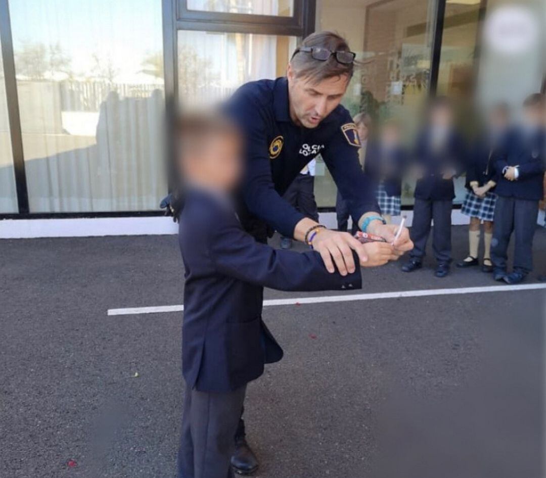 Un agente en un colegio de Gandia explicando el uso de los cohetes