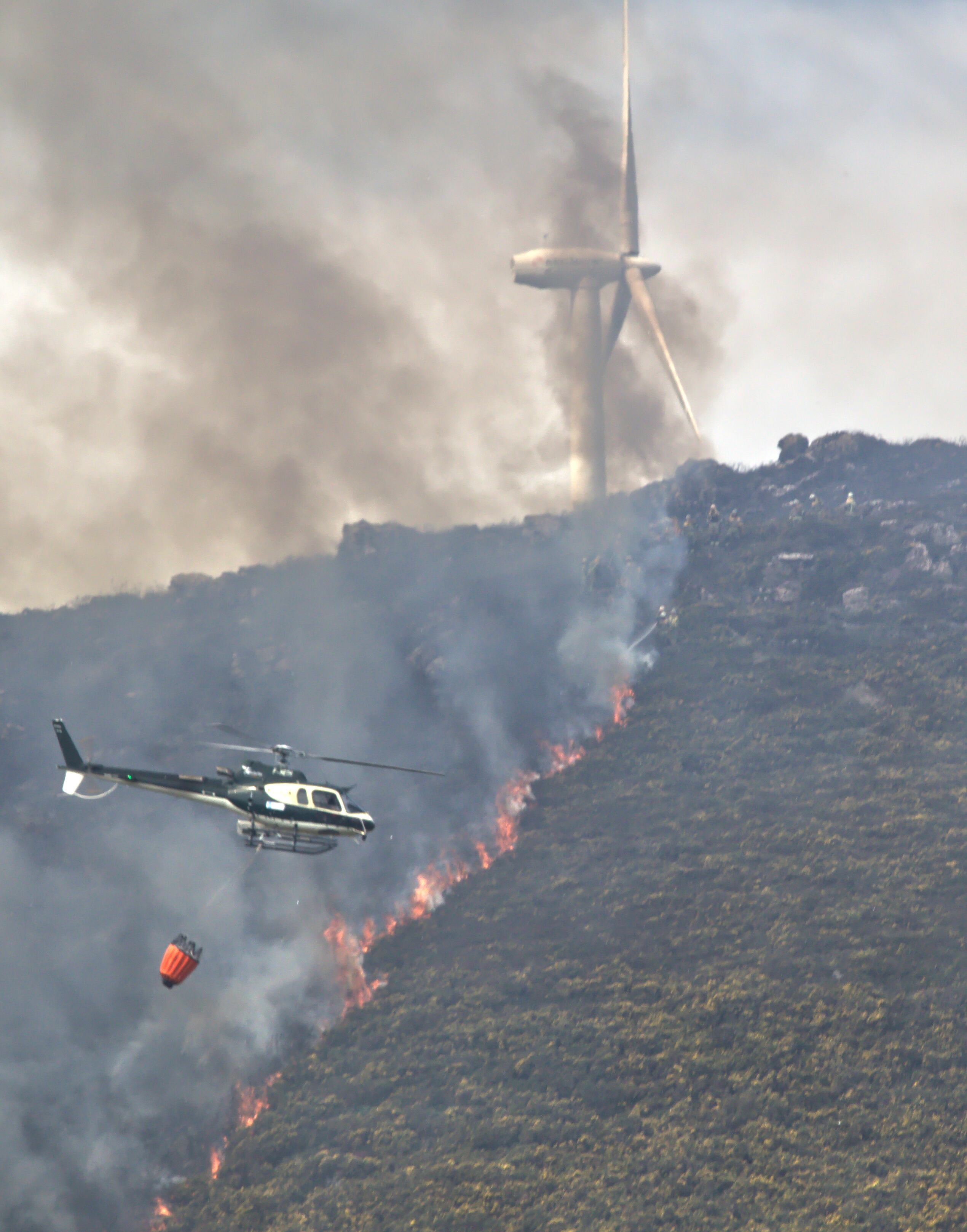 GRAF2404. LUGO, 17/04/2022.- El incendio forestal que se declaró a las 5:27 de la madrugada en el municipio lucense de Palas de Rei, parroquia de Moredo, afecta ya a unas 150 hectáreas, según la última estimación provisional de la Consellería de Medio Rural. En la imagen, un helicóptero controla las llamas en la Sierra Careón. EFE/ Eliseo Trigo
