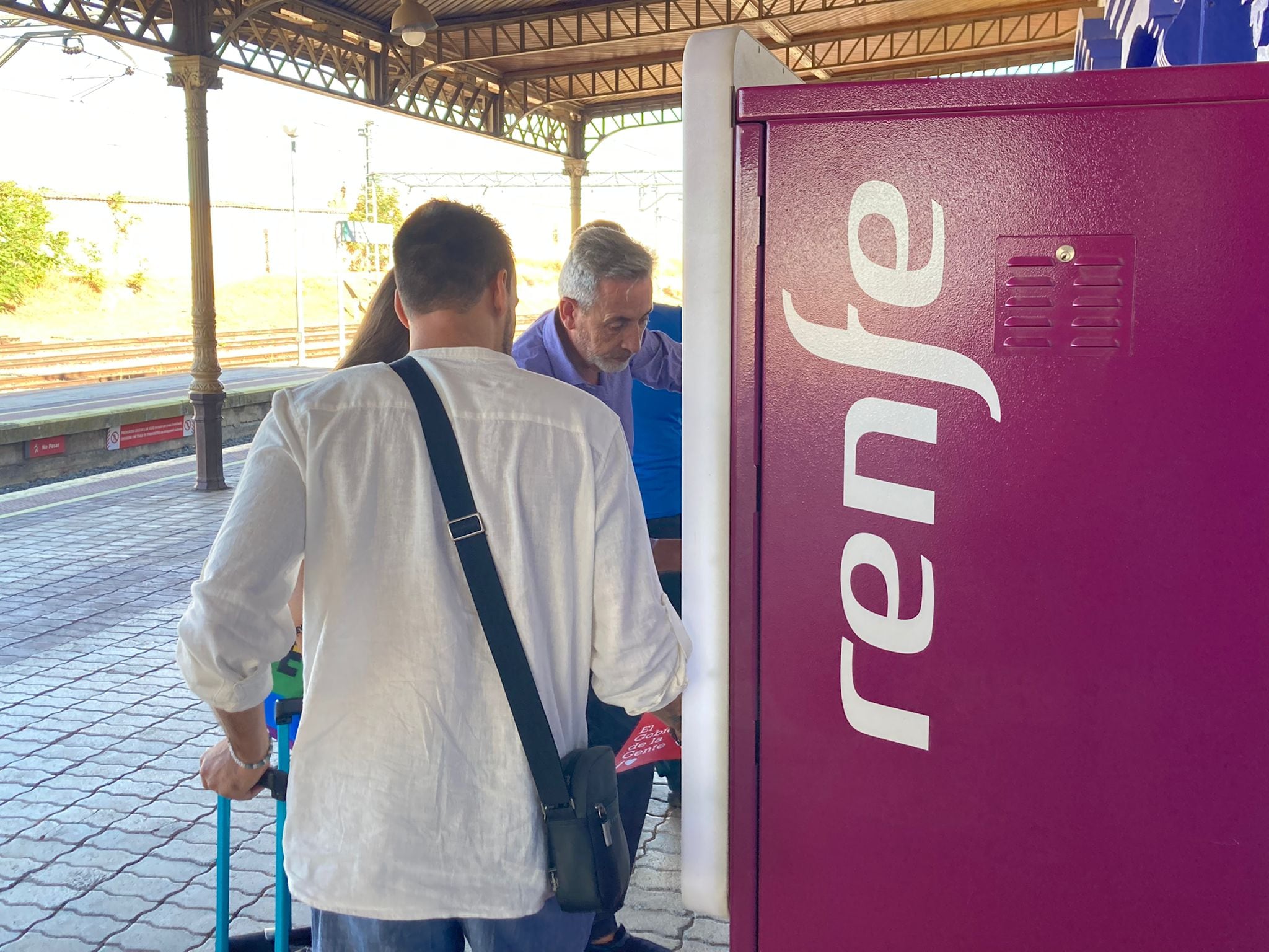 El alcalde de Valdepeñas y senador del PSOE, Jesús Martín, ayudando a sacar los abonos gratuitos a dos jóvenes en la estación vinatera