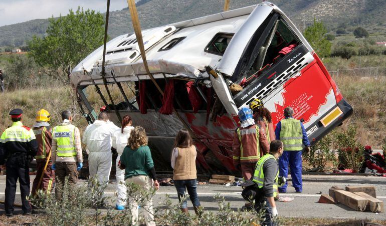 Efectius mirant com la grua està aixecant l&#039;autobús accidentat a l&#039;AP-7 a Freginals, aquest 20 de març de 2016. (Horitzontal)
