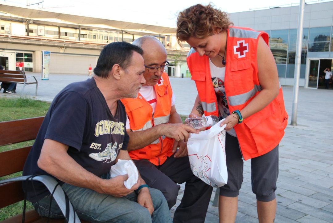 Els voluntaris de la Creu Roja reparteix un dels kits a en Vicente, que viu al carrer des de fa dos anys