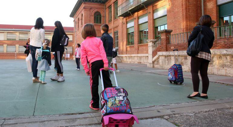 Una niña camina hacia el colegio.