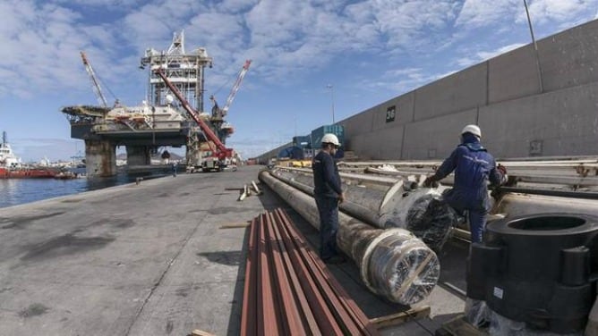 Trabajadores en el muelle, junto a una plataforma