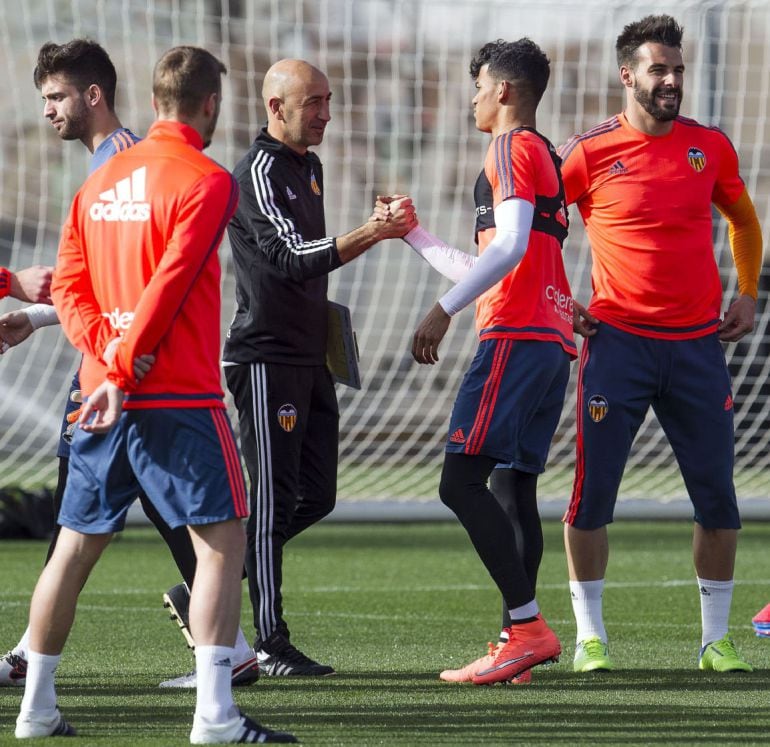 Uno de los técnicos de la planilla valencianista, Pako Ayestarán (4d), saluda los jugadores del primer equipo que esta tarde han participado en el primer entrenamiento tras las vacaciones de Semana Santa. EFE-Manuel Bruque.