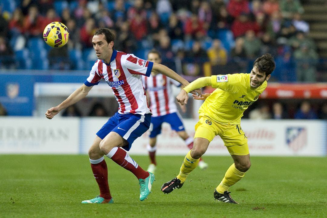Godín y Trigueros pelean un balón en 2014