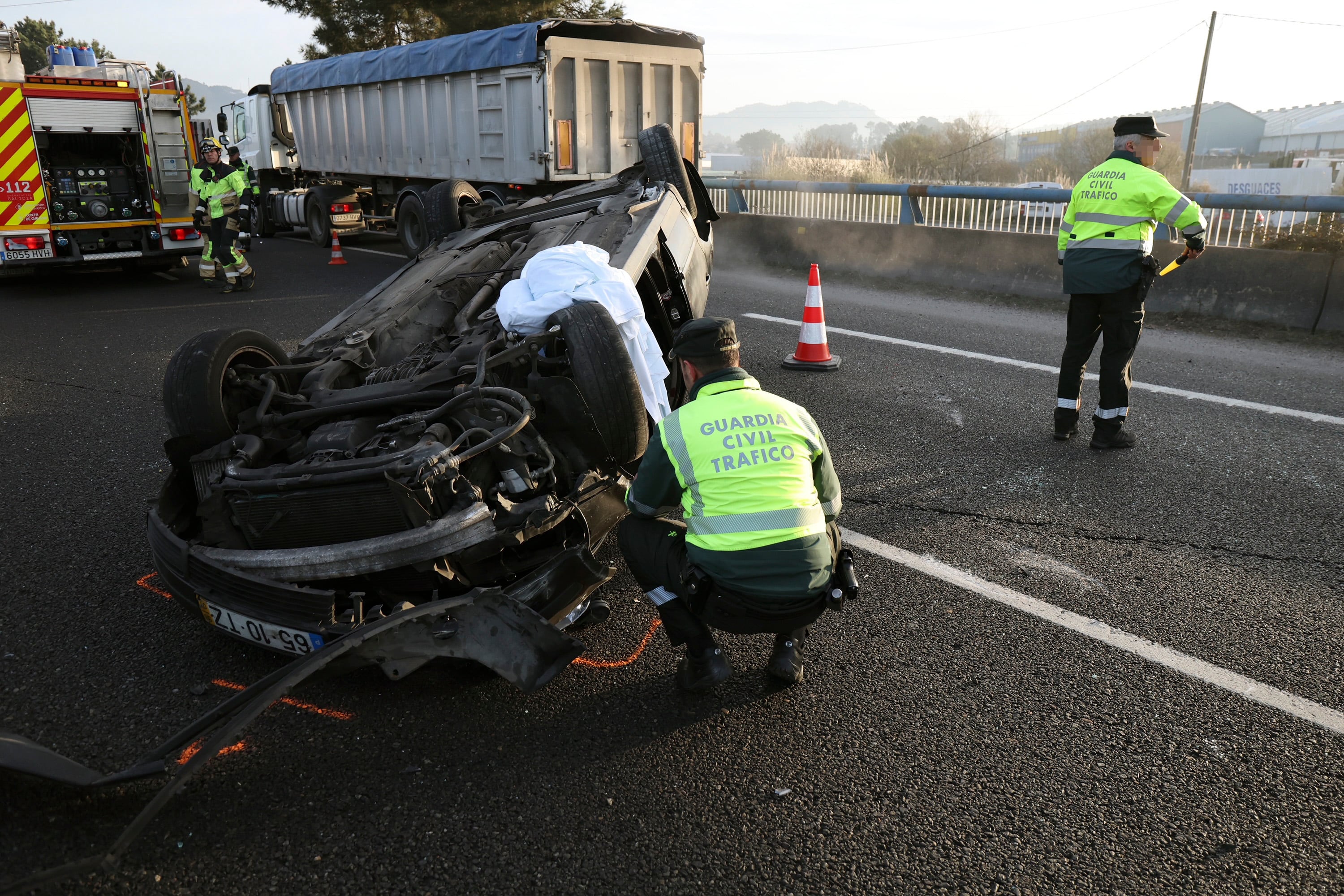 VIGO, 14/02/2023.- Dos agentes de la Guardia Civil de Tráfico investigan en el lugar tras el accidente de tráfico registrado en el km 22 de la A-55, a la altura de la parroquia de San Salvador de Budiño, y que se ha saldado con la muerte del conductor de un turismo. EFE/Sxenick
