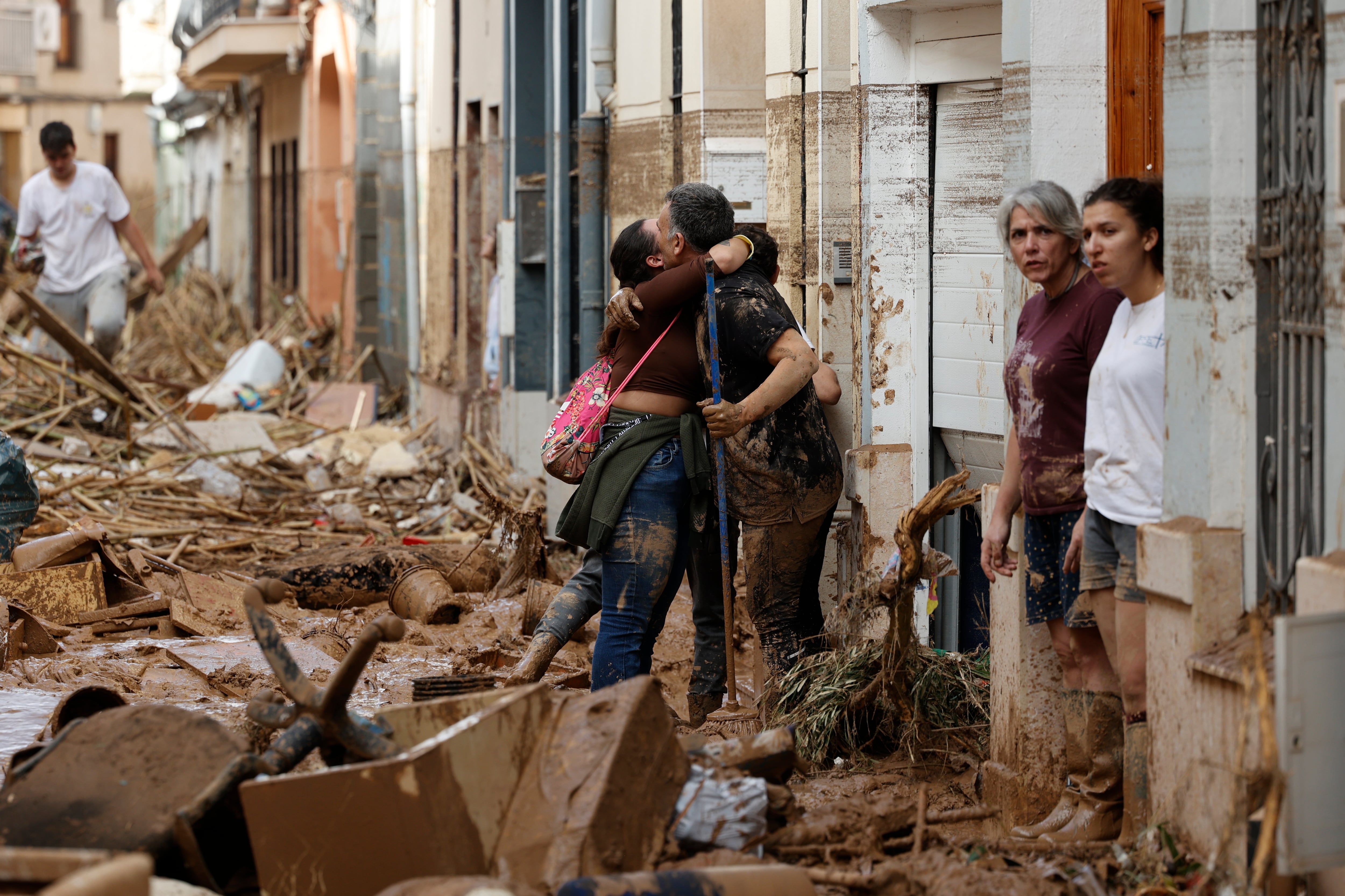 Unas personas que realizan labores de limpieza y desescombro se abrazan en Paiporta, Valencia, este jueves.