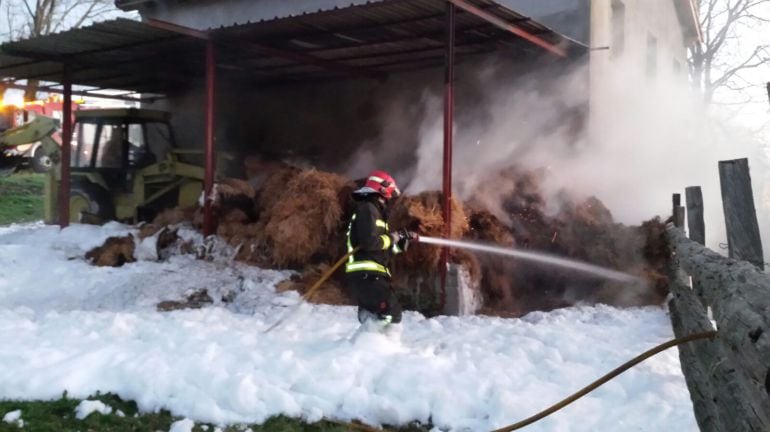 Los bomberos, ayudados por los propietarios de la explotación y vecinos del municipio, extinguen el incendio.