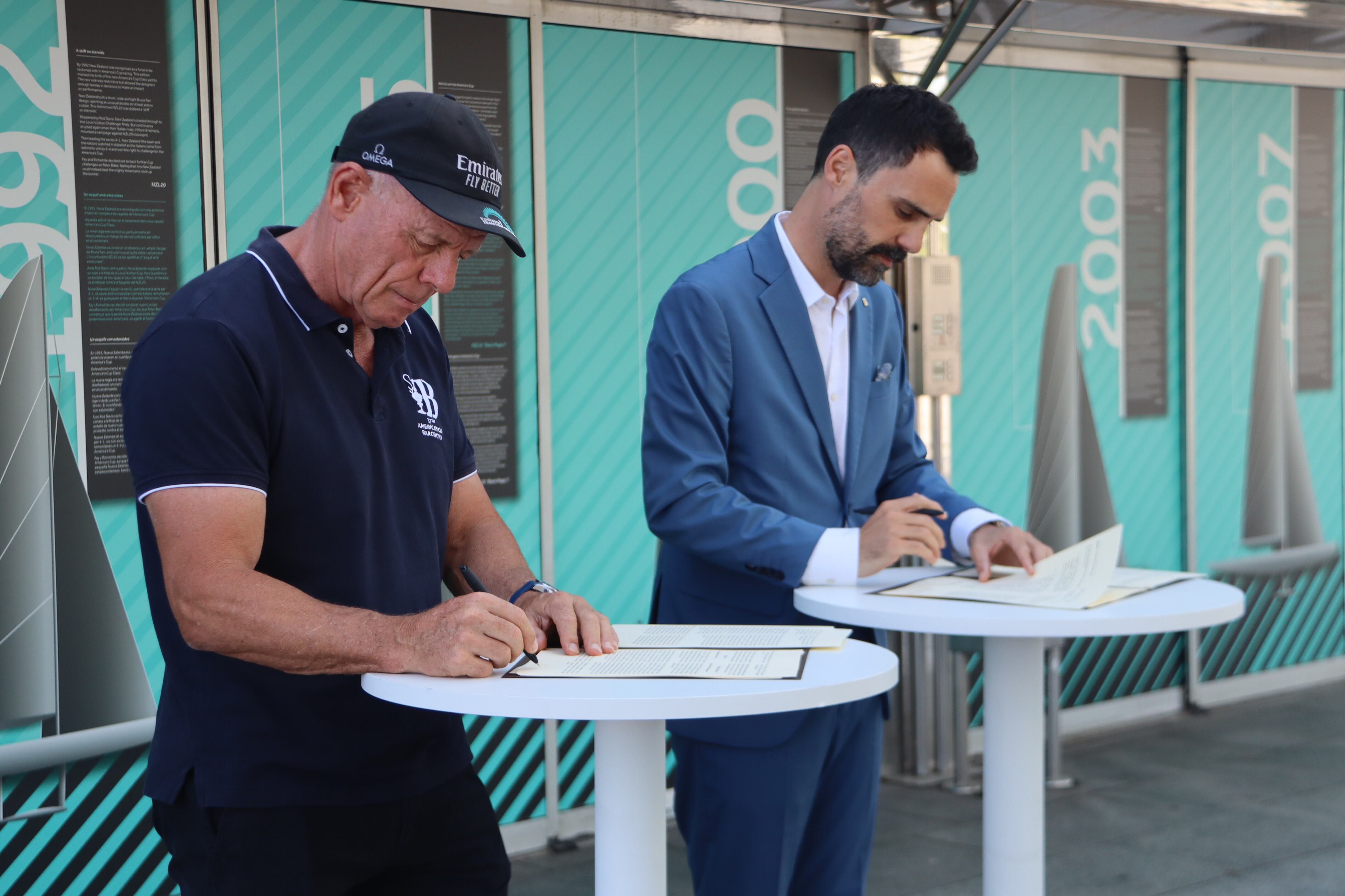 El conseller d'Empresa i Treball, Roger Torrent, i el director executiu de l'America's Cup Barcelona, Grant Dalton, signen el conveni de col·laboració per garantir el llegat de la competició a Catalunya.