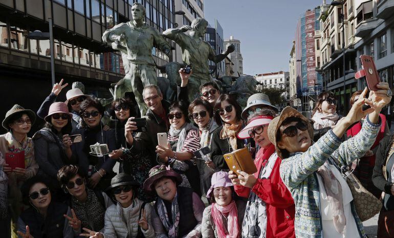 Un grupo de turistas orientales se hacen un &quot;selfie&quot; junto al monumento al encierro en Pamplona