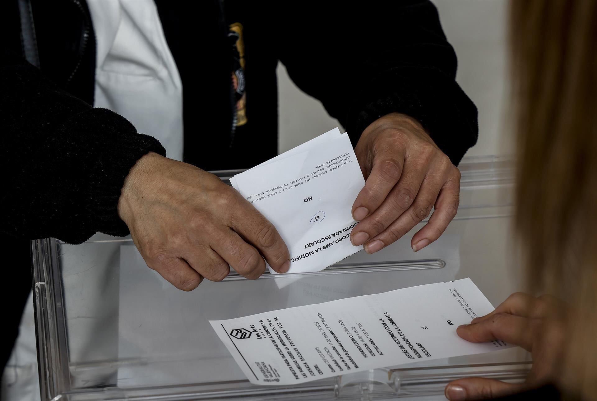 Un hombre vota en la consulta a las familias sobre el cambio de jornada escolar en un colegio de València