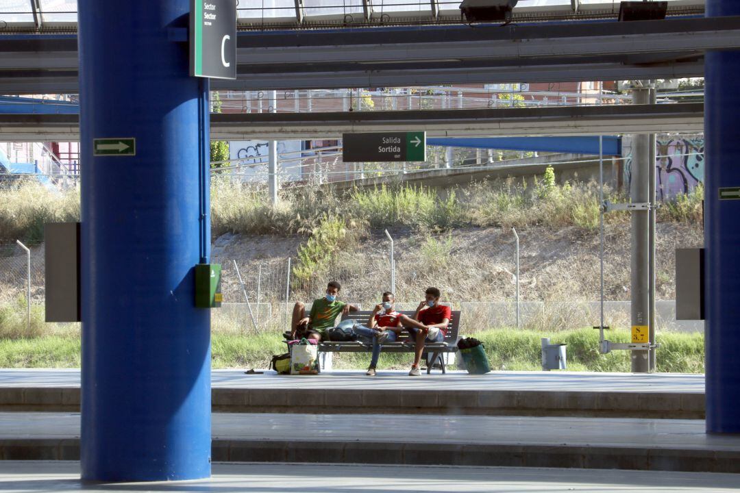 Tres jóvenes esperan en la estación de Lleida