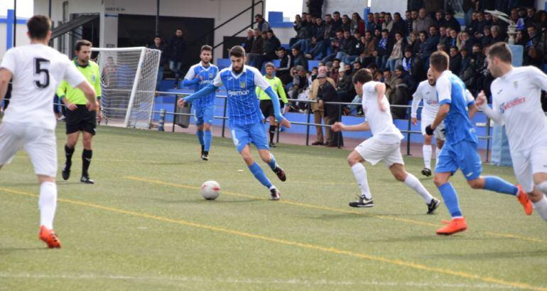 Borja Jiménez conduciendo la pelota ante varios jugadores del Arcos