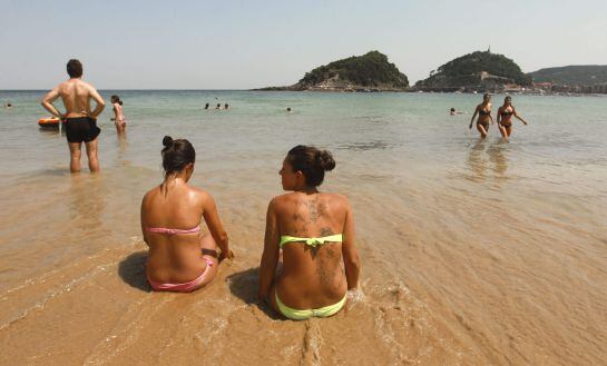 Donostiarras y visitantes disfrutan en la playa de Ondarreta de San Sebastián de los cielos despejados y las altas temperaturas que han superado los 35 grados en las horas centrales del día.
