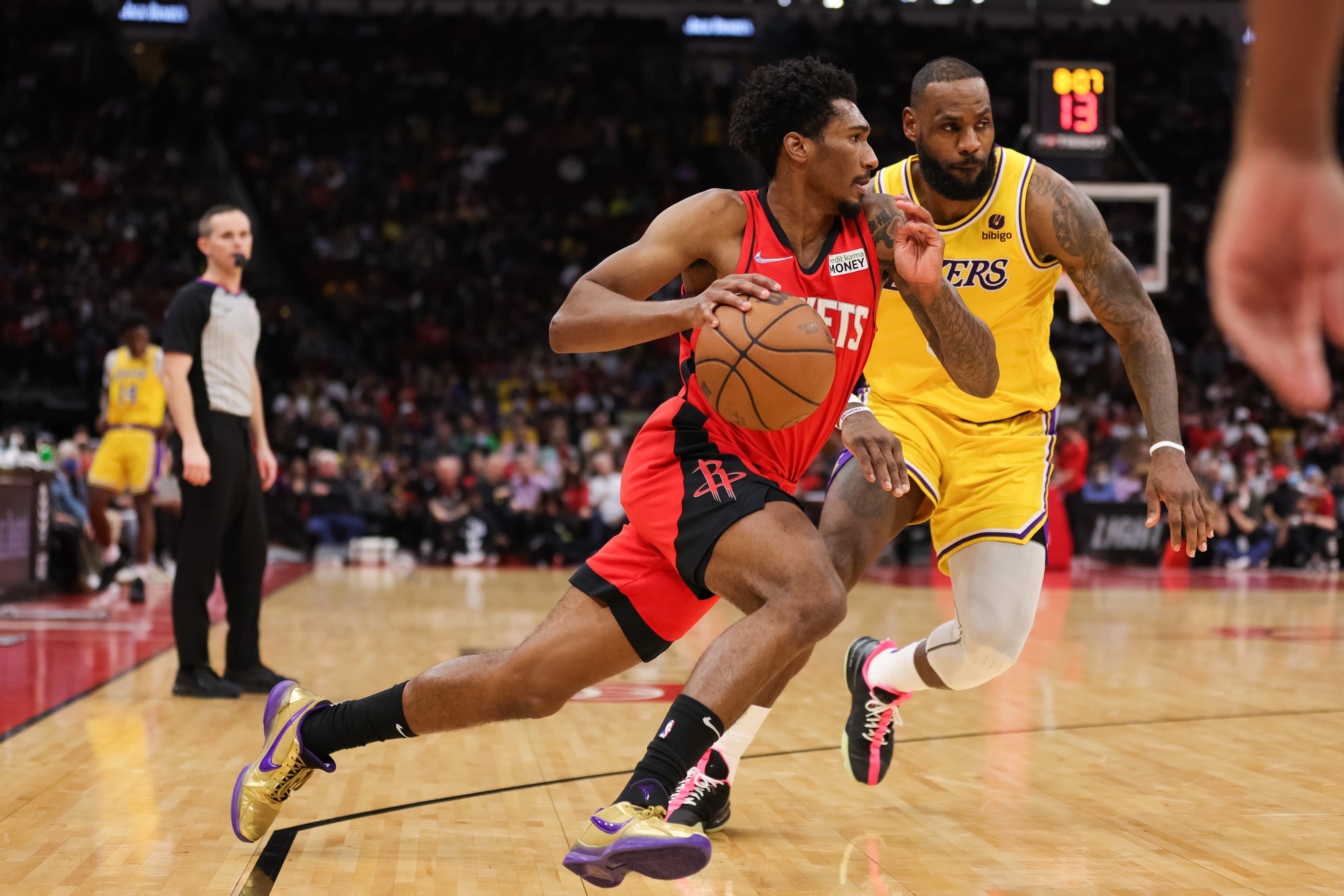 HOUSTON, TEXAS - DECEMBER 28: Armoni Brooks #7 of the Houston Rockets controls the ball ahead of LeBron James #6 of the Los Angeles Lakers during the first half at Toyota Center on December 28, 2021 in Houston, Texas. NOTE TO USER: User expressly acknowledges and agrees that, by downloading and or using this photograph, User is consenting to the terms and conditions of the Getty Images License Agreement. (Photo by Carmen Mandato/Getty Images)