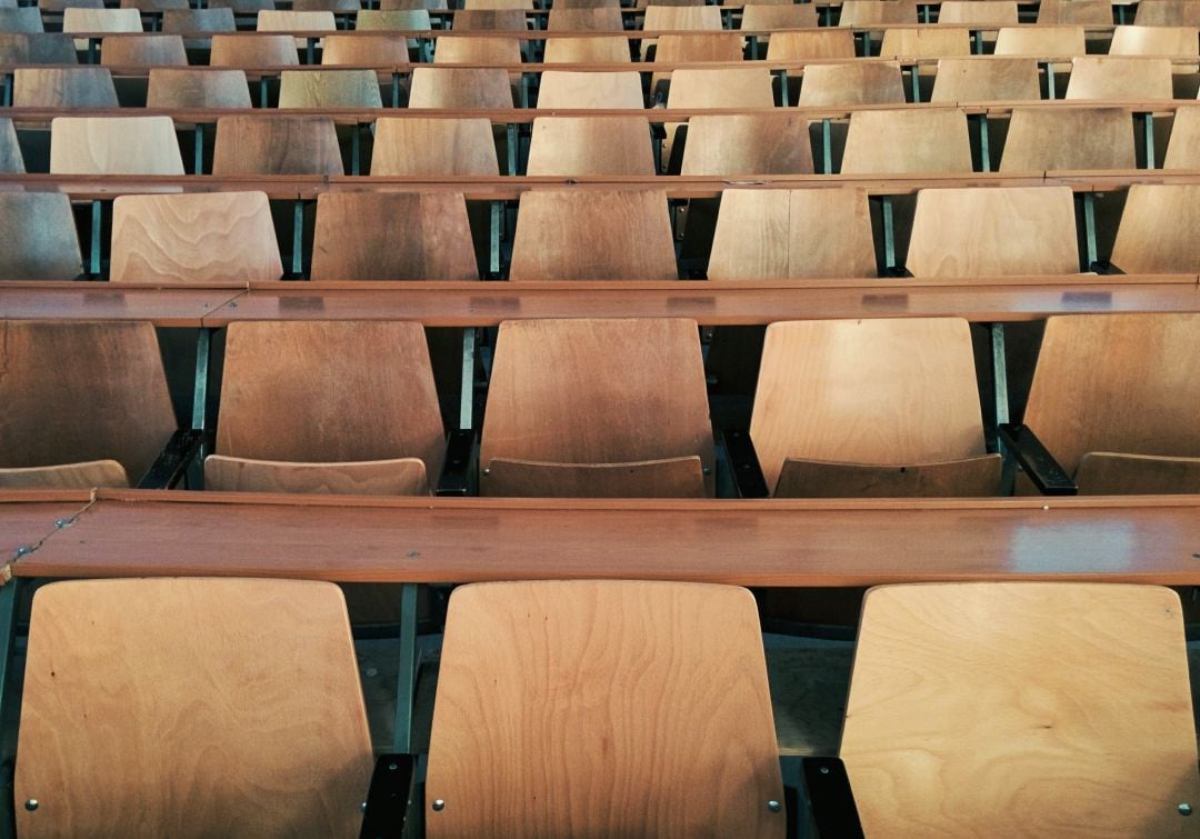 Aula con sillas y mesas vacías.