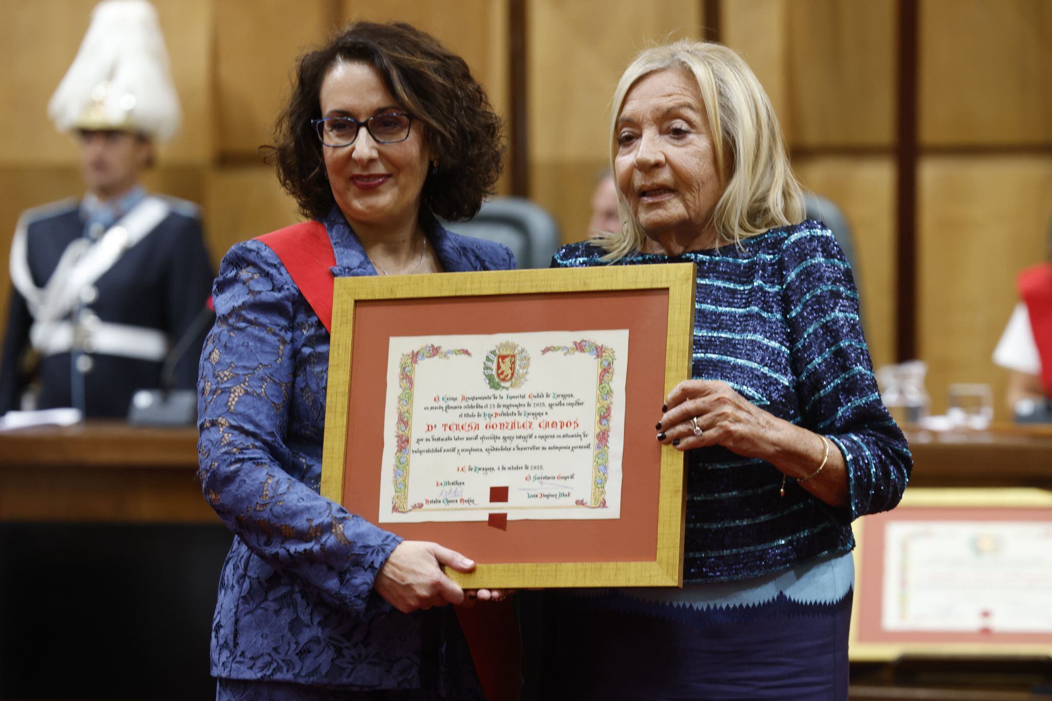 Fiestas del Pilar. Acto de la Entrega de Medallas y Distinciones de 2025 de Zaragoza. Hijos predilectos: Teresa González, presidenta de Casa Cuna Anikaren. Junto a la concejala de Vox, Eva Torres