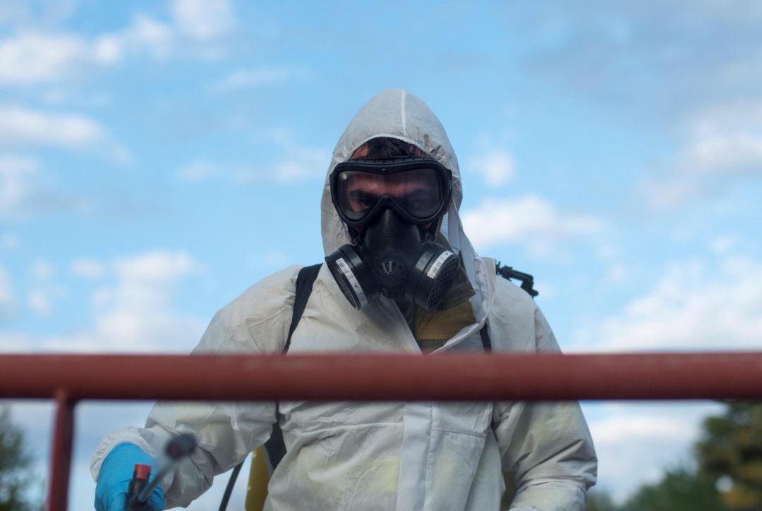 Un voluntario del servicio de prevención y defensa contra los incendios forestales realiza labores de desinfección en el centro de salud de Xunqueira de Ambía